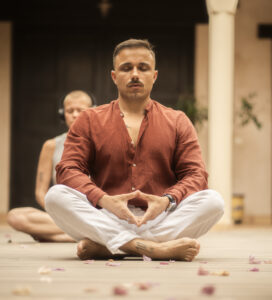 Tino Fuchs meditiert in einer Yoga-Pose, Fokus auf Achtsamkeit und innere Ruhe.